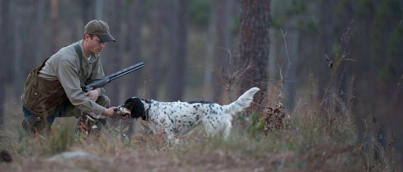 Chasseur agenouillé à côté du chien