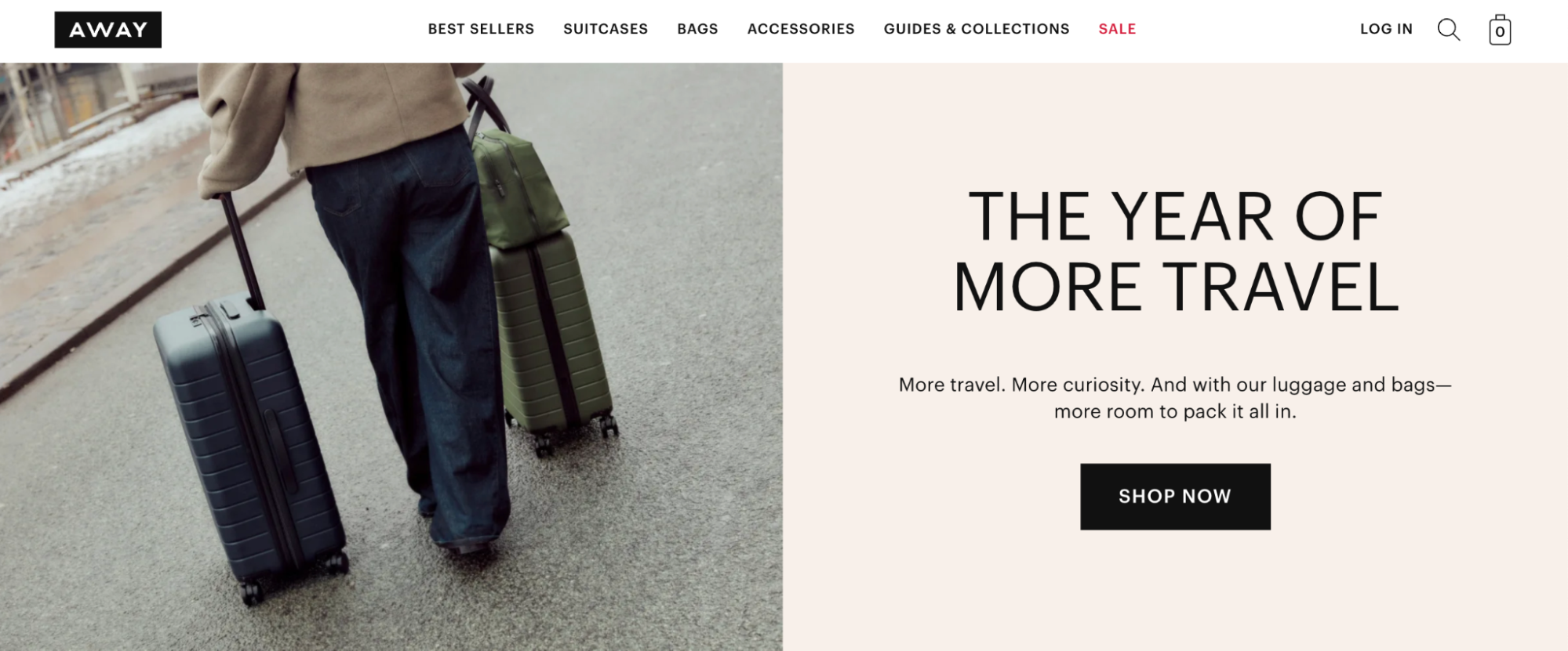 Person seen from behind walking on a wet street pulling two rolling suitcases (navy hard-shell and olive with a duffel on top); right side shows headline text "THE YEAR OF MORE TRAVEL" and a "Shop Now" button.