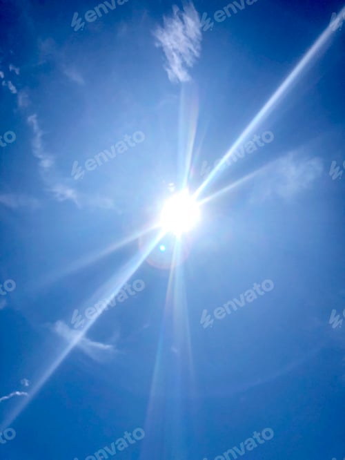 Preview: Sun shining bright up on the blue sky with shooting sun rays.