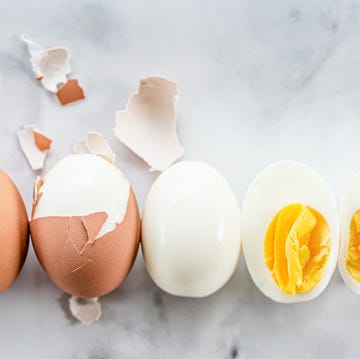 Hard Boiled Egg a row of hard boiled eggs showing the order of hard boiling an egg, peeling, and cutting