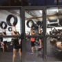 Physical fitness enthusiasts exercising in gym, holding large tires