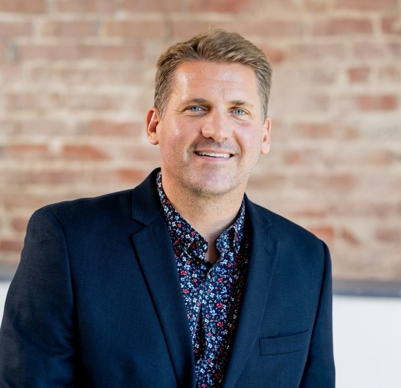 White man wearing a navy blue jacket.