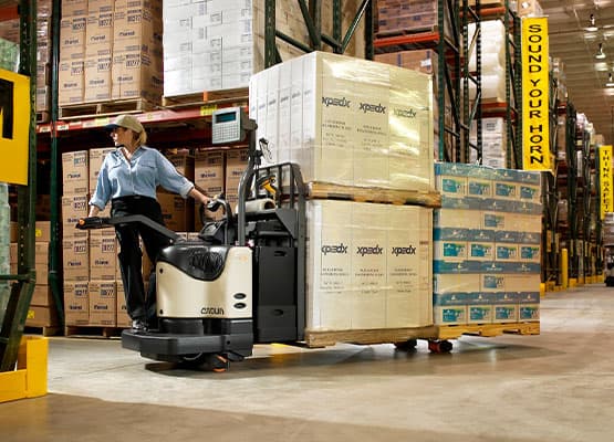 Crown PE 4500 Pallet Jack Forklift moving pallets in a warehouse setting.