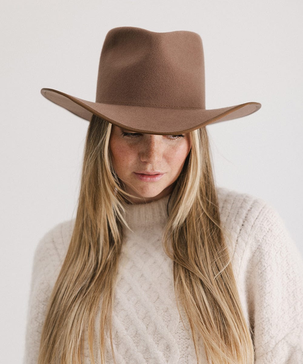 Woman wearing a chocolate colored felt western hat and a cream sweatshirt against a white background #color_chocolate